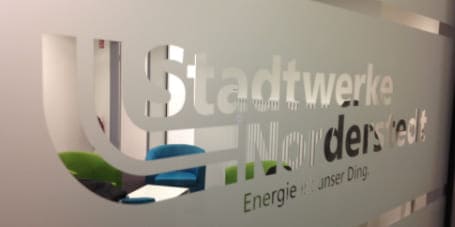 Glasfront mit gläserner Eingangstür eines Büros, Folierung mit Milchglasfolie und Ausstanzung durch Folien Fischer